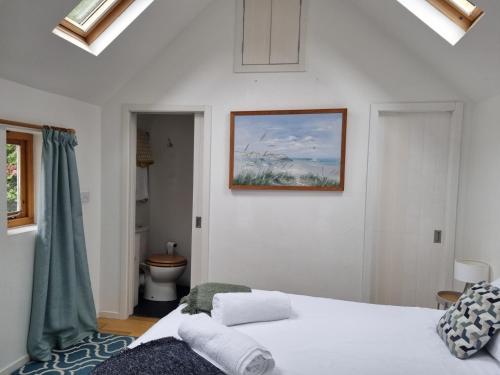 a bedroom with a bed and a picture on the wall at Roses Cottage and Studio in Bideford