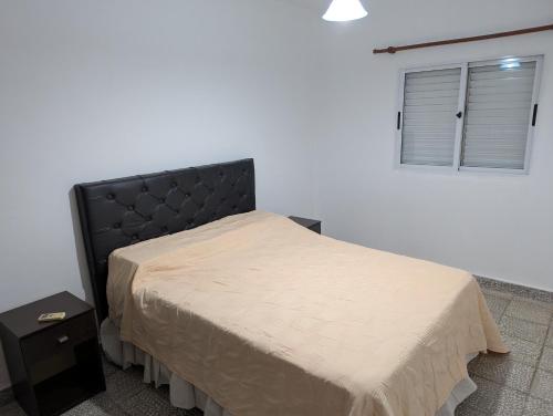 een slaapkamer met een bed met een zwart hoofdeinde en een raam bij dale dpto in Chilecito