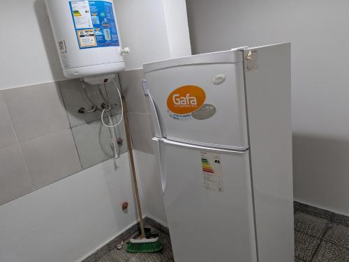 een witte koelkast in een keuken met een watertank bij dale dpto in Chilecito