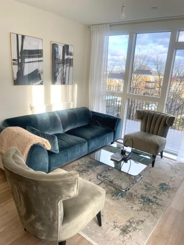 a living room with a blue couch and a chair at Beautiful 1 bedroom Luxury Apartment near Erith Station in Erith