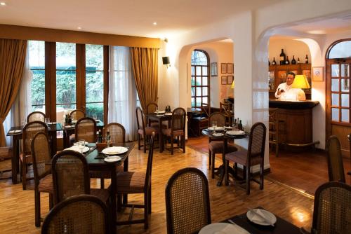 a restaurant with tables and chairs in a room at Hotel Presidente in Santiago