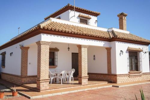 a white house with tables and chairs in it at Casa Ana Mari in Conil de la Frontera