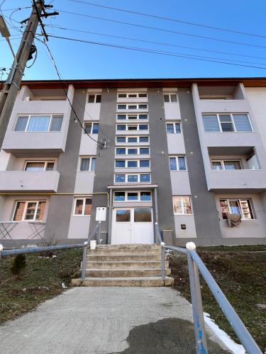 an apartment building with stairs in front of it at Apartament Dor de Munte Cavnic in Cavnic