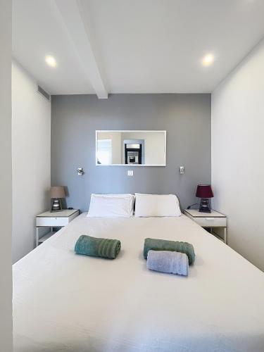 une chambre avec un grand lit blanc avec deux oreillers dans l'établissement Croisette I - 4 pers - Front de mer - Climatisé, à Cannes