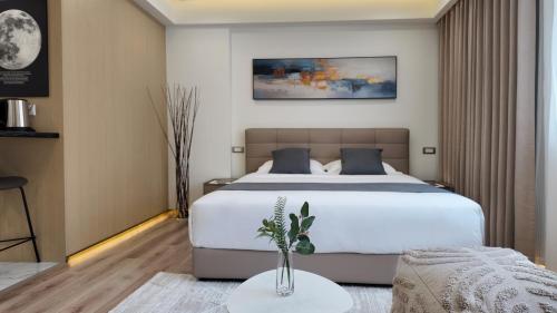 a bedroom with a large bed and a table at CC LUX Suites in Piraeus