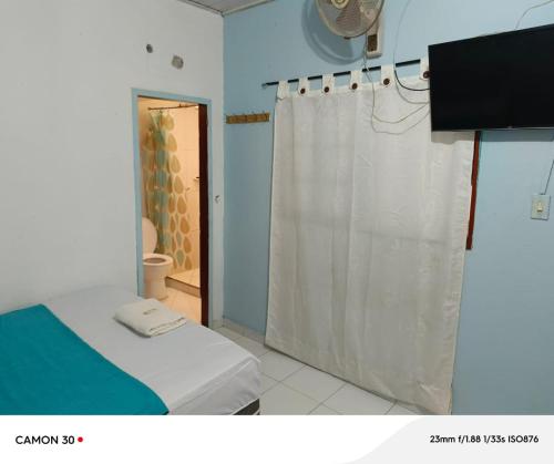 a bathroom with a shower and a bed with a shower curtain at Alojamiento LETICIA in Leticia