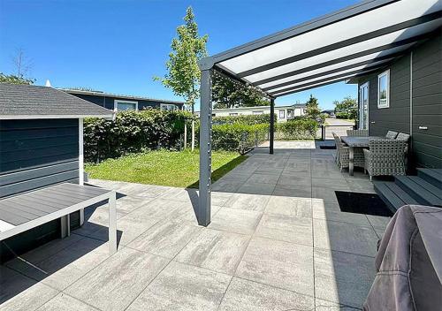 a patio with a bench and a picnic table at Chalet am See in Lathum