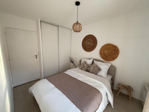 une chambre avec un lit avec des draps blancs et des oreillers dans l'établissement Cozy appartement avec terrasse et parking, à Nancy