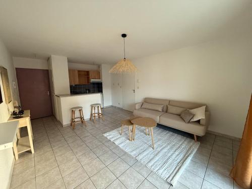 un salon avec un canapé et une table dans l'établissement Cozy appartement avec terrasse et parking, à Nancy