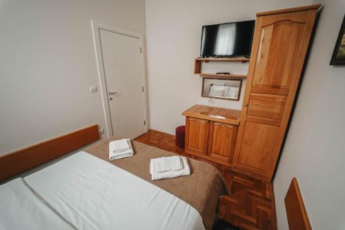a small bedroom with a bed and a tv at B&B Passage in Sremska Mitrovica