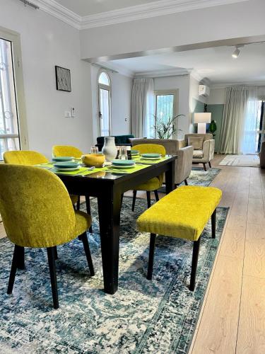 a dining room with a table and yellow chairs at 6th of October Sun & Shade in 6th Of October