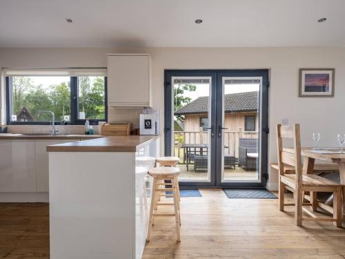 a kitchen and dining room with a table and chairs at Cabin W Hot Tub, Outdoor Dining In National Park in Otterburn