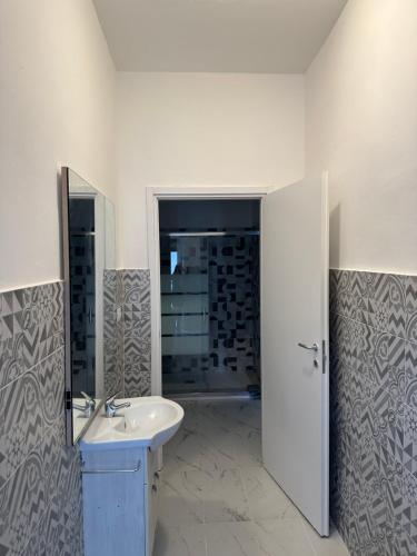 a white bathroom with a sink and a mirror at Centro Lecco Piazza Manzoni in Lecco