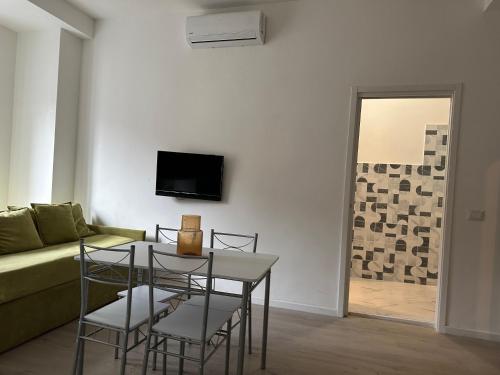 a living room with a table and chairs and a couch at Centro Lecco Piazza Manzoni in Lecco