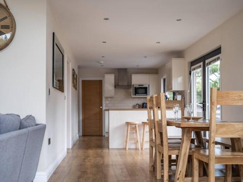 a kitchen and living room with a table and chairs at Lodge W Hot Tub, Outdoor Dining In National Park in Otterburn