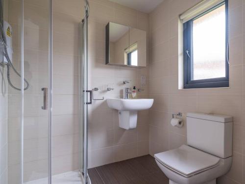 a bathroom with a toilet and a sink and a shower at Lodge W Hot Tub, Outdoor Dining In National Park in Otterburn