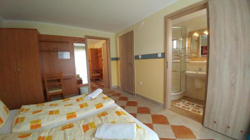 um quarto com uma cama e um banheiro em Zöld Vendégház em Balatonfüred