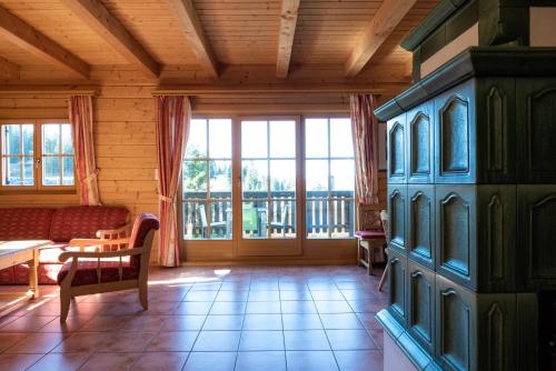 a living room with a couch and a large window at Feriendorf Koralpe Chalet Alpenperle in Hartelsberg