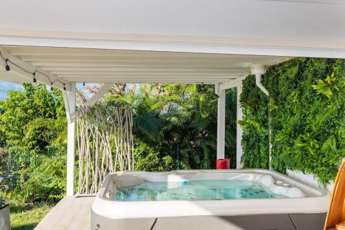 a jacuzzi tub on the deck of a house at Mont Choisy Vue imprenable sur la mer et spa 2BDcanapé in Happy Bay