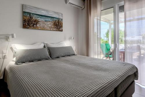 a bedroom with a bed with a picture on the wall at Sea view - Villa Emmanouella in Makry Gialos
