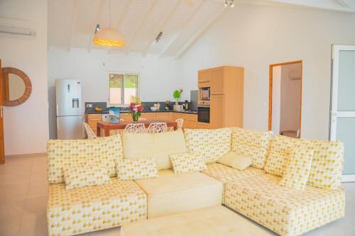 Friar's BayVilla Sunset Heights - La Savane的客厅里有一张沙发和一个厨房