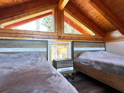 a bedroom with two beds in a log cabin at Red Cariboo Resort in Anahim Lake