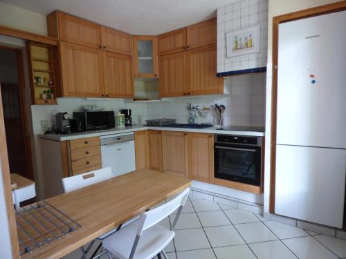 une cuisine avec des armoires en bois et un réfrigérateur blanc dans l'établissement Villa les muriers, à Manosque