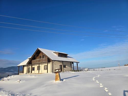 a house in the snow with footprints in the snow at wellness Chata u Pinkasů in Písečná
