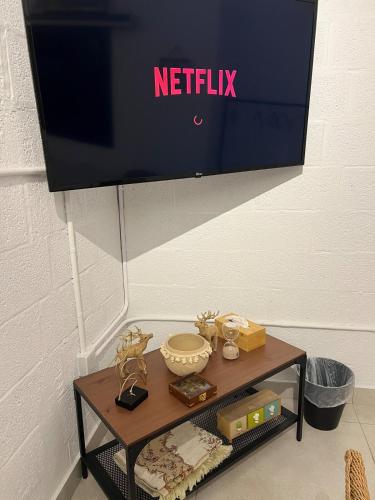 a tv on a wall with a table with a tv at Welcome to The AlSultan Studio in Jeddah
