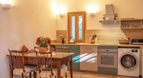 une cuisine avec une table et une machine à laver dans l'établissement I Carbonni - Bergerie 80m2 entre mer et montagne, à Sotta