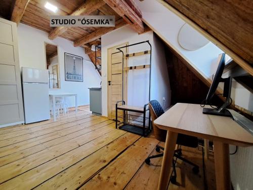 an attic office with a desk and a computer on a table at Górskie apartamenty Kowary in Kowary