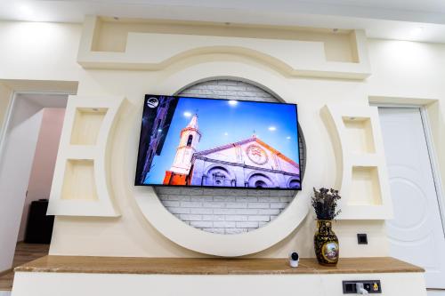a flat screen tv on a wall with a church at Villa Ashtarak in Ashtarak