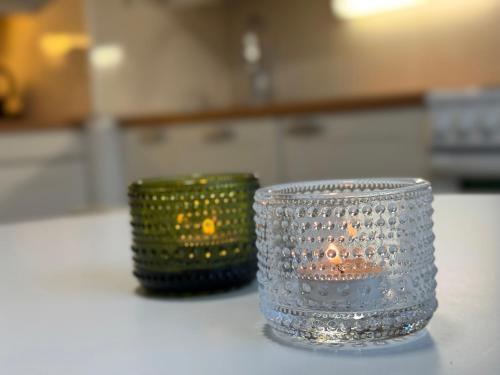 two green baskets sitting on a table with a clear glass at Two-room apartment in Lappeenranta