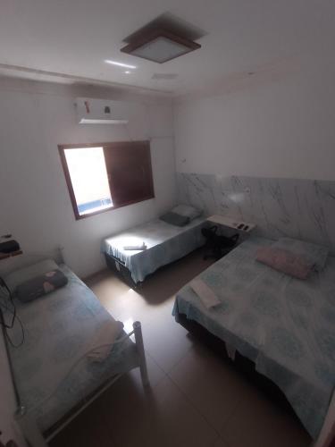 a room with two beds and a window at Pousada Maria Bonita in Macau