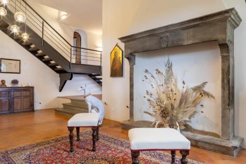 a living room with two chairs and a fireplace at Dimora Boccaccio by VacaVilla in Strada