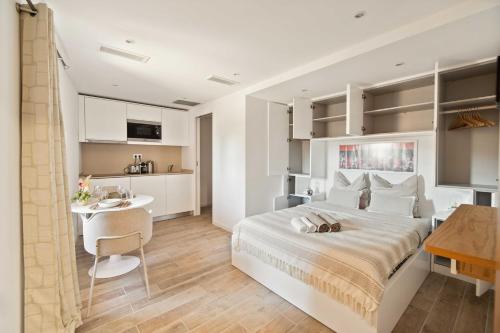 une chambre avec un grand lit et une cuisine dans l'établissement Residence-Allard-Saint-Tropez, à Saint-Tropez