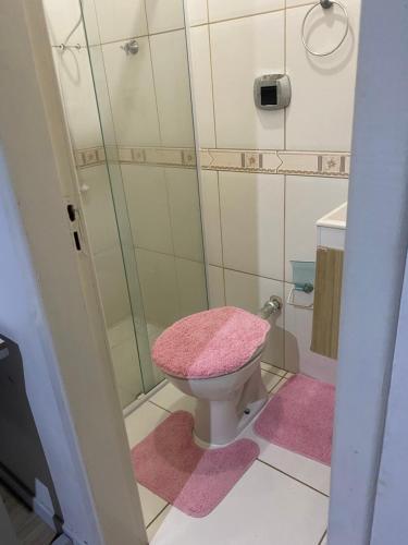 a bathroom with a pink toilet and a shower at Hospedagem Doce lar in Joinville