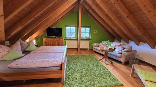 a room with a bed and a couch in a attic at Ferienwohnung Die Reblaus in Erlabrunn