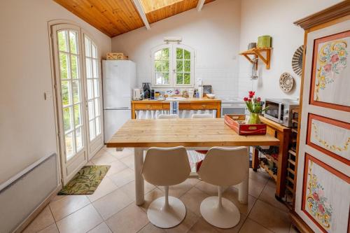 une cuisine avec une table et des chaises en bois dans l'établissement Maisonnette à l étang, à Vélizy-Villacoublay