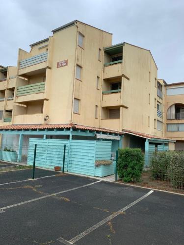 un parking vide devant un immeuble dans l'établissement Narbonne plage appartement vue sur mer, à Narbonne-Plage