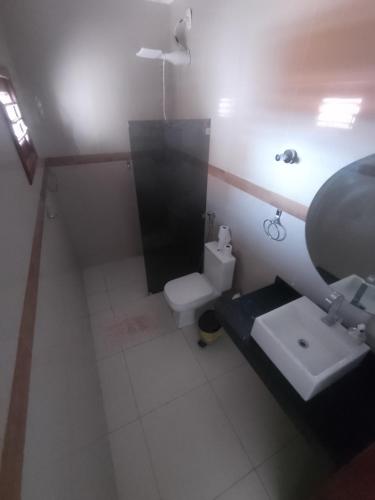 a small bathroom with a toilet and a sink at Pousada Maria Bonita in Macau