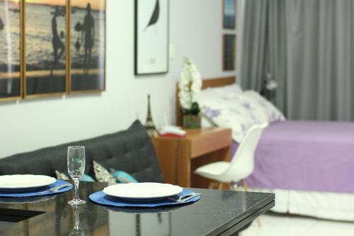 sala de estar con mesa y cama en Flat Farol da Barra, en Salvador