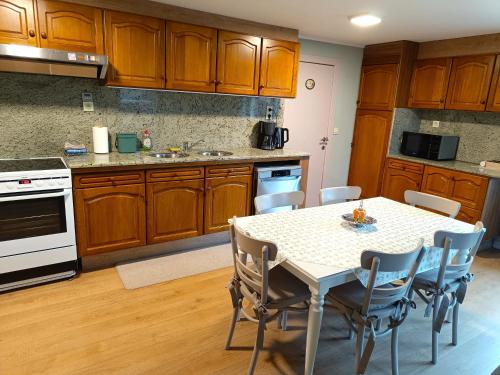 a kitchen with wooden cabinets and a table with chairs at Hoeve Hofgaarde in Heers