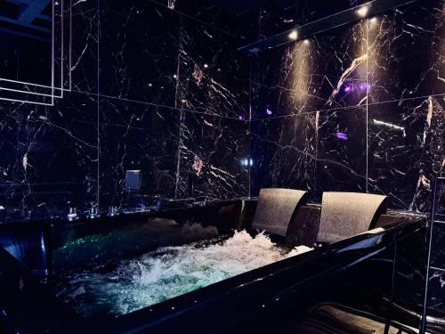 - une piscine d'eau avec 2 chaises dans la chambre dans l'établissement Love Room - Dayan 1, à Villeurbanne