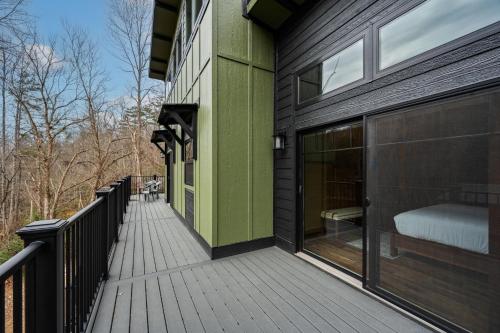 a wooden deck with a bed on a house at Sunset in the Glades in Gatlinburg