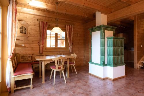 a dining room with a table and chairs in a cabin at Feriendorf Koralpe Chalet Bergglocke in St. Gertraud