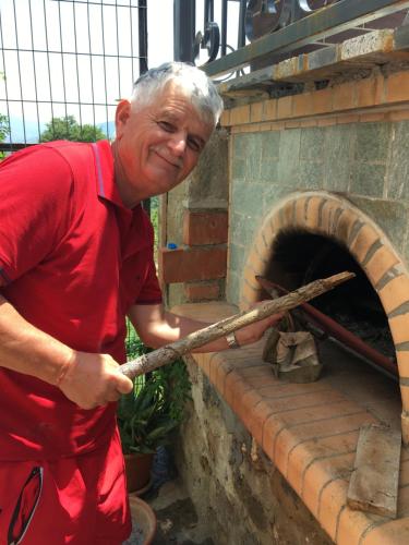 a man is standing next to a brick oven at Kulla Xhemalit in Batra e Madhe