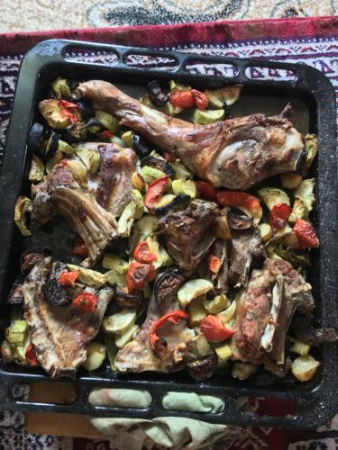 a tray of food with meat and vegetables at Kulla Xhemalit in Batra e Madhe