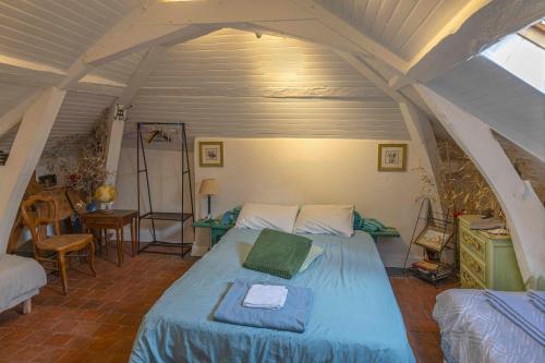 a bedroom with a bed in an attic at Chambre d'Hôtes Les Jardins de Marie, SCI Charles III in Bernay