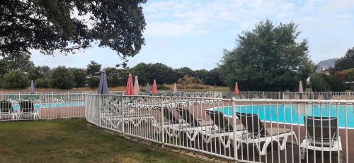 - un groupe de chaises longues et de parasols à côté de la piscine dans l'établissement Maison Village Port-Bourgenay, à Saint-Hilaire-de-Talmont